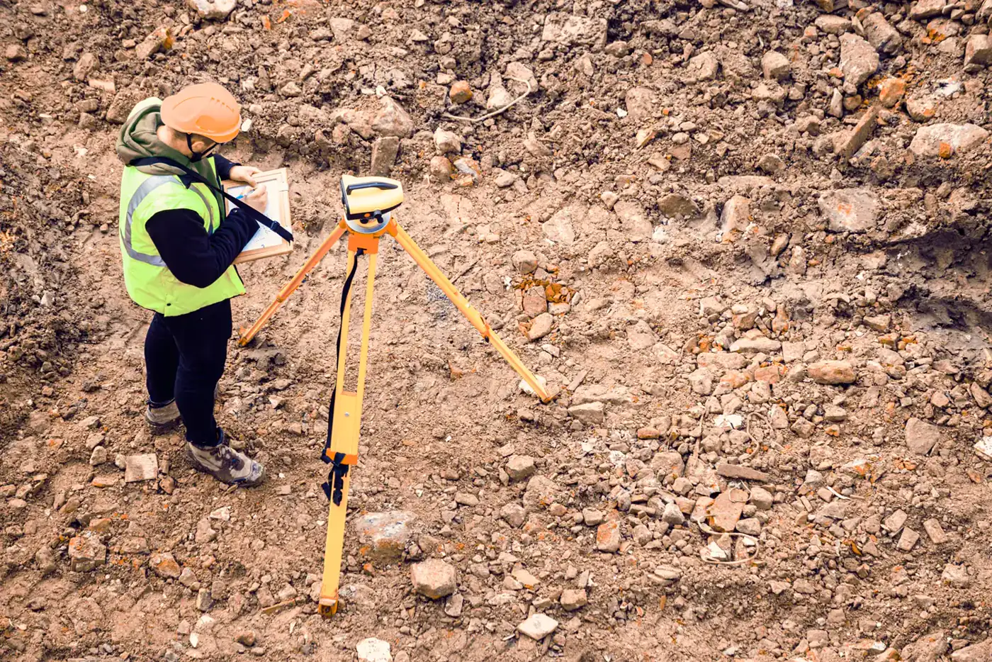 Topógrafo operando equipamento de GPS em terreno rural